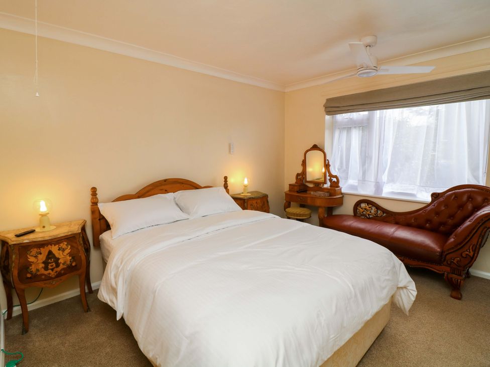 A bedroom with a bed and nightstand with lamp at 5 Overstone Drive Wisbech