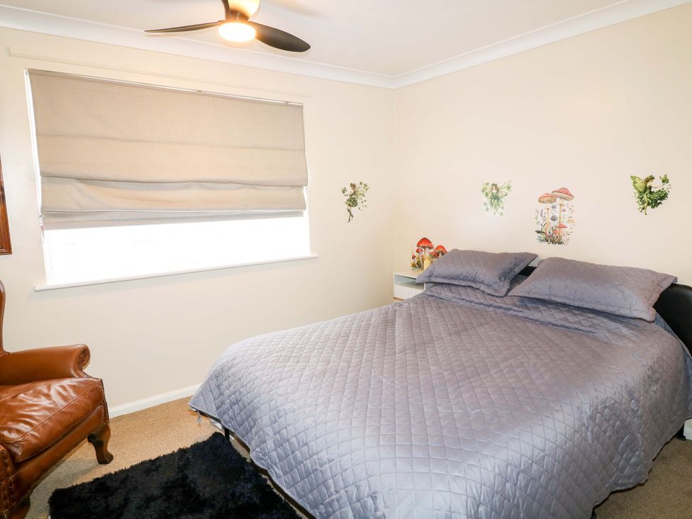 A bedroom with a bed and chair at 5 Overstone Drive in Wisbech