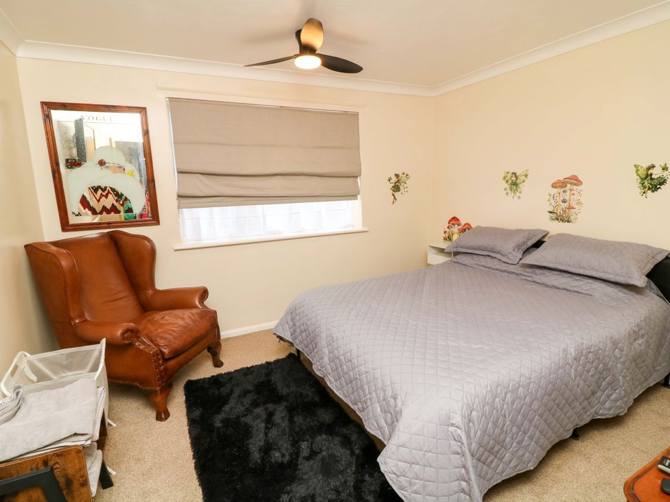 A bedroom with a bed and a chair at 5 Overstone Drive in Wisbech