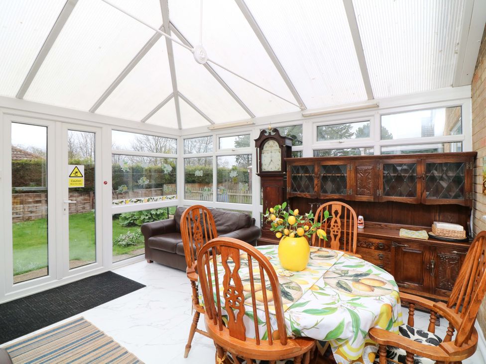A conservatory with a table and chairs at 5 Overstone Drive, Wisbech
