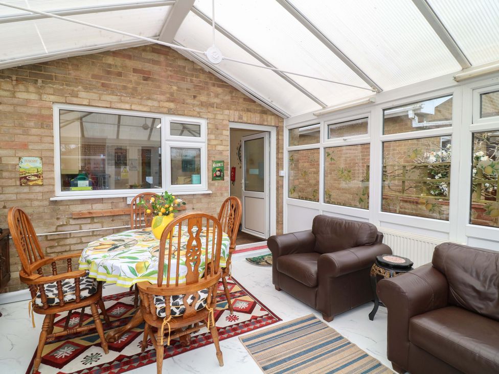 A conservatory with a table and chairs at 5 Overstone Drive in Wisbech