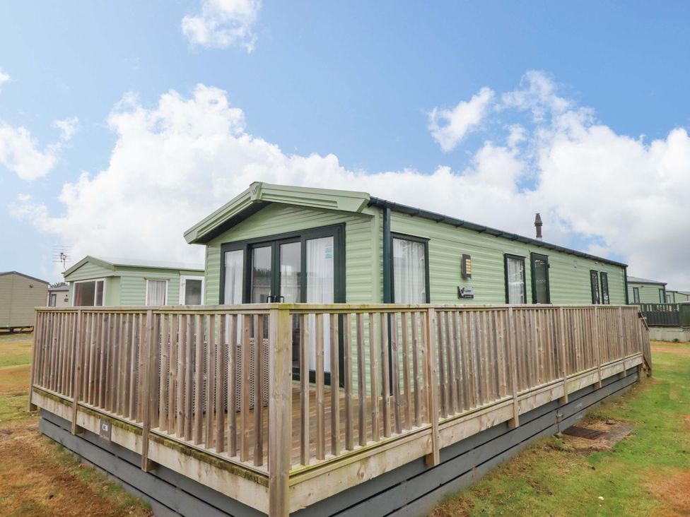 A green caravan with a deck at Sea Breeze C38 Dyffryn Seaside Estate Dyffryn Ardudwy