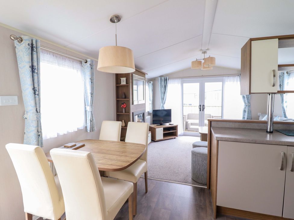 A dining room with a table and chairs at Sea Breeze C38 Dyffryn Seaside Estate Dyffryn Ardudwy