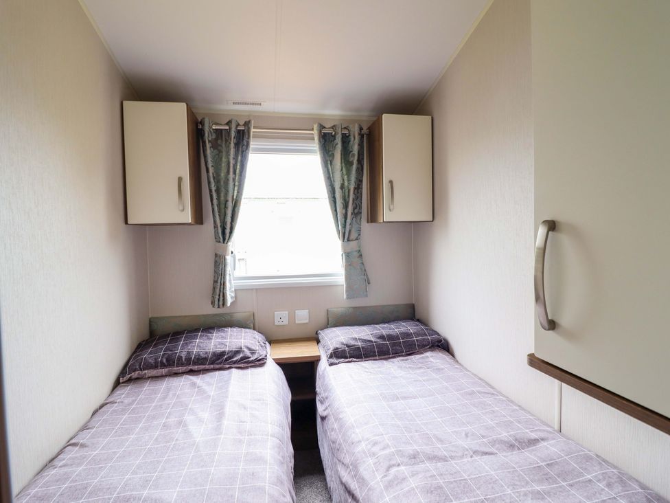 A bedroom with two single beds and wall cabinets at Sea Breeze C38 Dyffryn Seaside Estate Dyffryn Ardudwy
