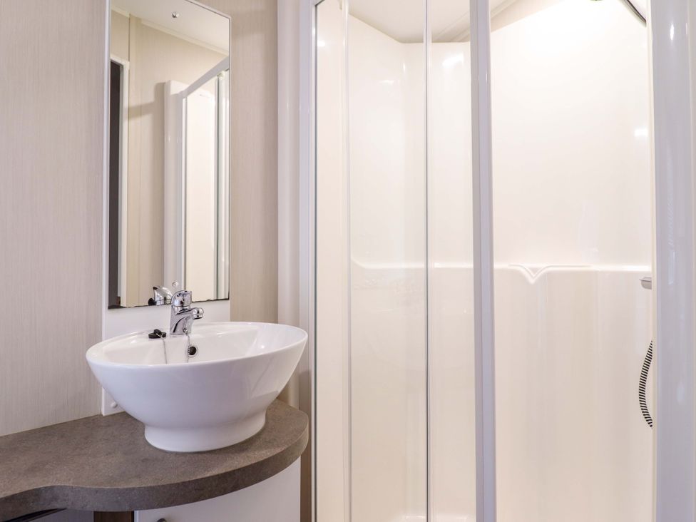 A bathroom with a sink and shower at Sea Breeze C38 Dyffryn Seaside Estate Dyffryn Ardudwy