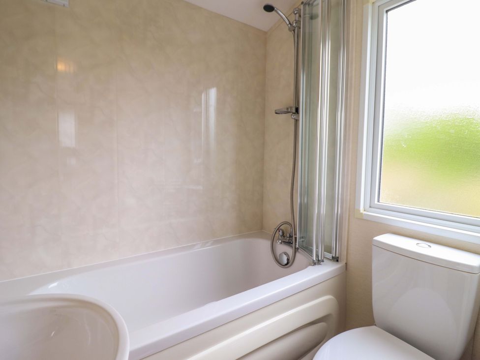 A bathroom featuring a bathtub and toilet at Beach Retreat E19 Dyffryn Seaside Estate Dyffryn Ardudwy