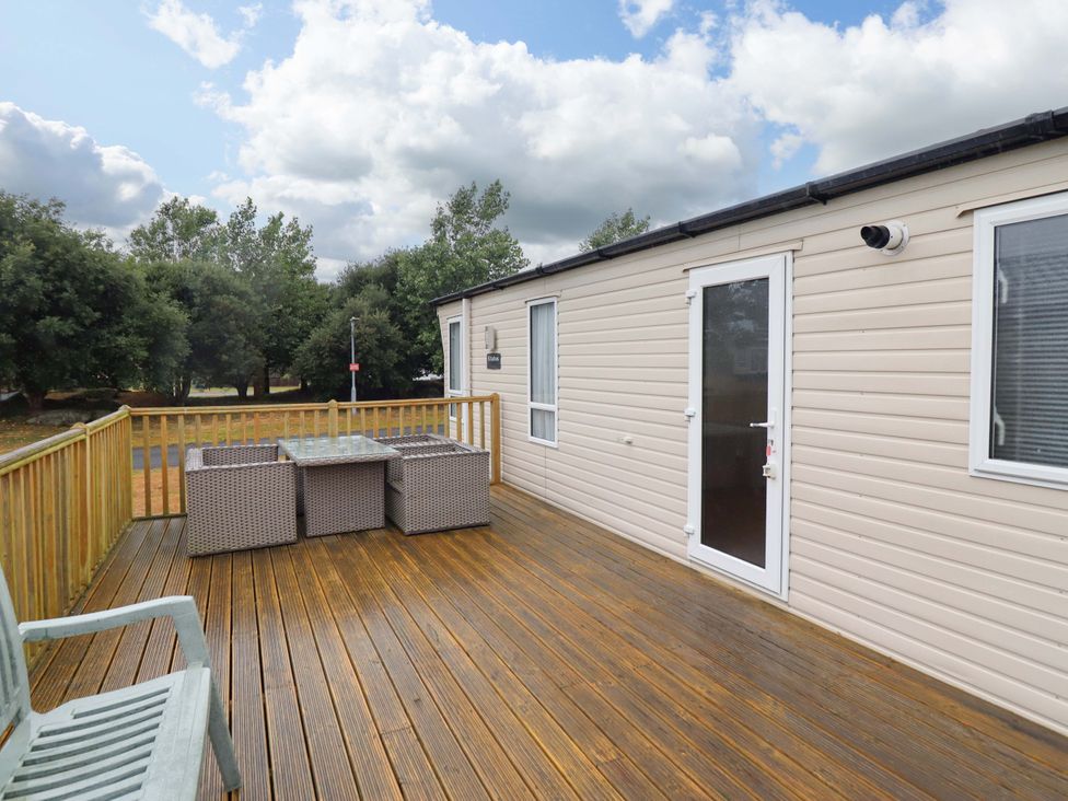 An outdoor seating area with table and chairs at Beach Retreat E19 Dyffryn Seaside Estate in Dyffryn Ardudwy