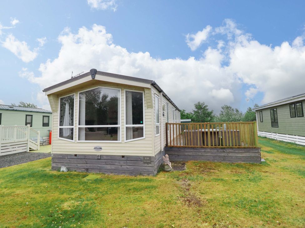 A caravan with a wooden deck at Beach Retreat E19 Dyffryn Seaside Estate Dyffryn Ardudwy