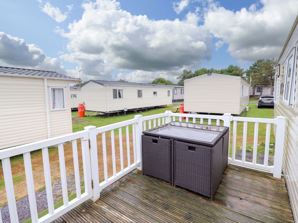 A deck with a table overlooking caravans at Beachcombers Barmouth Bay Holiday Park Talybont