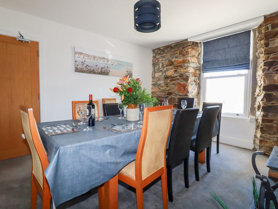 A dining room with a table set for dinner at Tregundy Farmhouse Perranporth