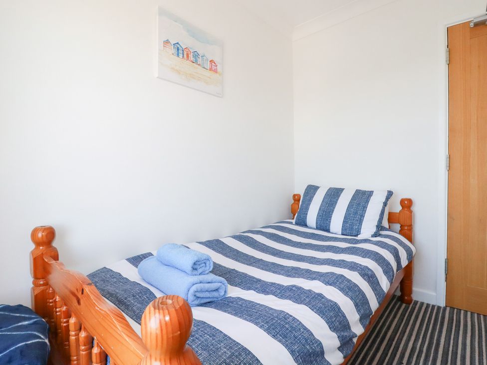 A bedroom with a single bed and towels at Tregundy Farmhouse in Perranporth