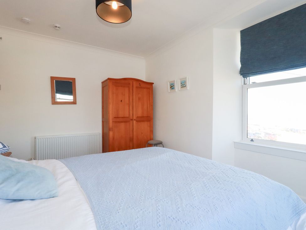 A bedroom with a bed and wardrobe at Tregundy Farmhouse in Perranporth