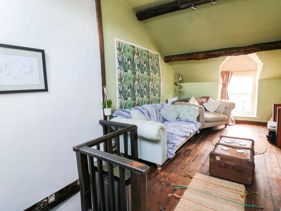 A living room with a sofa and storage trunk at The Little Laura Ashley House in Machynlleth