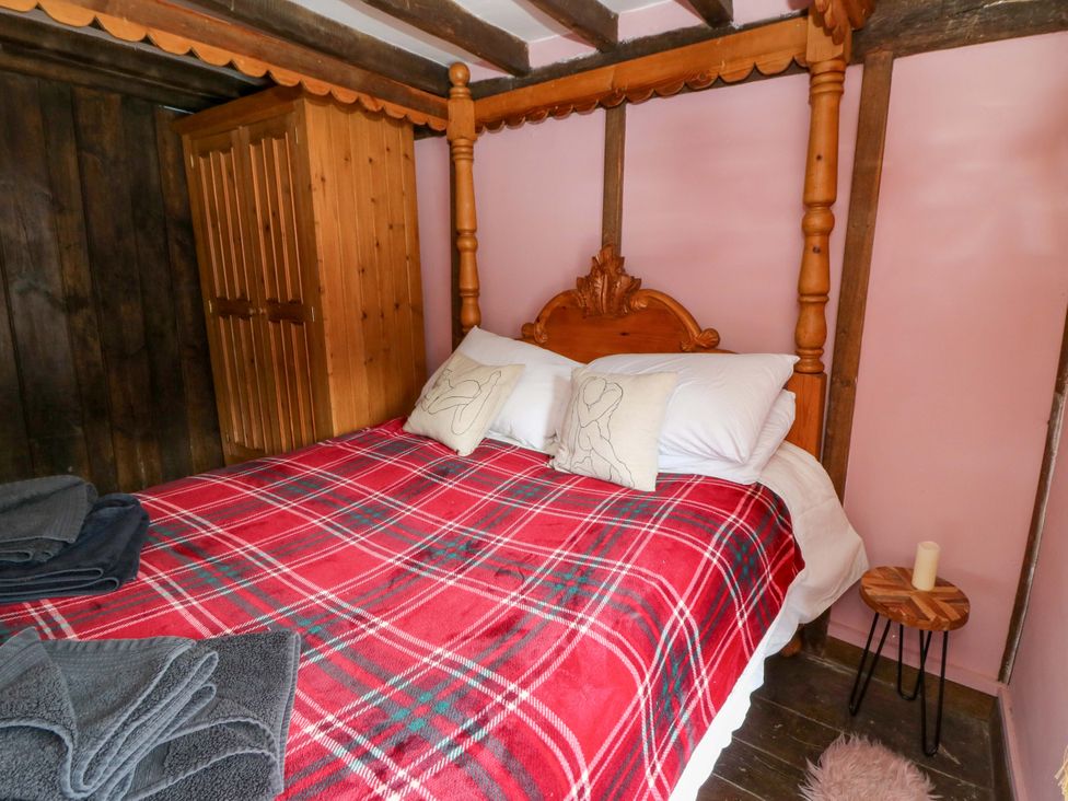 A bedroom with a bed and wardrobe at The Little Laura Ashley House in Machynlleth