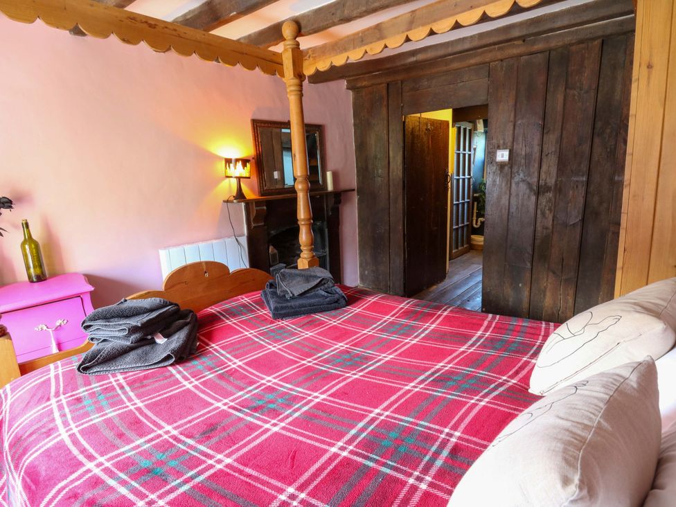 A bedroom with a four-poster bed and mirror at The Little Laura Ashley House in Machynlleth