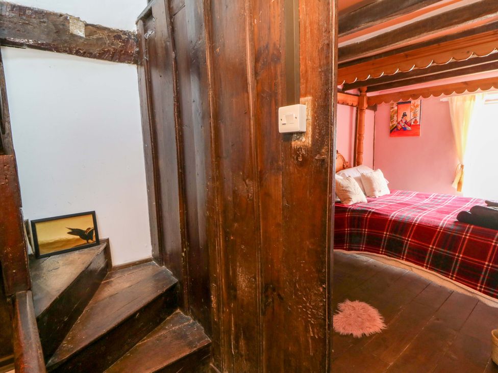 A bedroom with a bed and stairs at The Little Laura Ashley House Machynlleth
