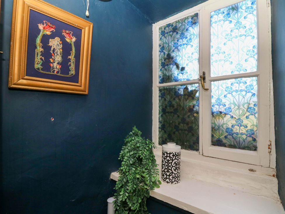 A bathroom with a window and framed artwork at The Little Laura Ashley House in Machynlleth
