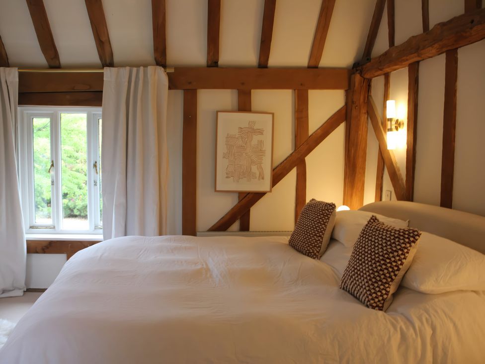 A bedroom with a bed and window at Headland Barn in Maldon