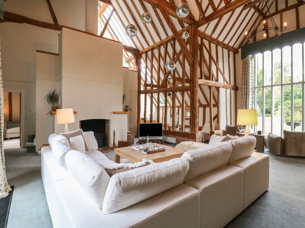 A living room with a sofa, coffee table, and television at Headland Barn in Maldon