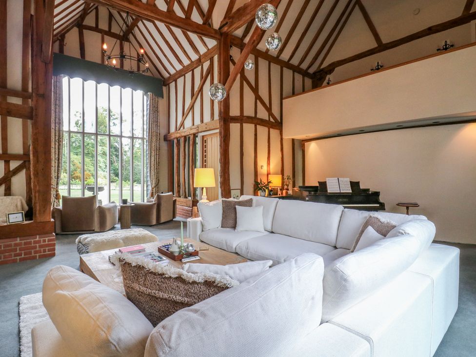 A living room with a sofa and piano at Headland Barn in Maldon