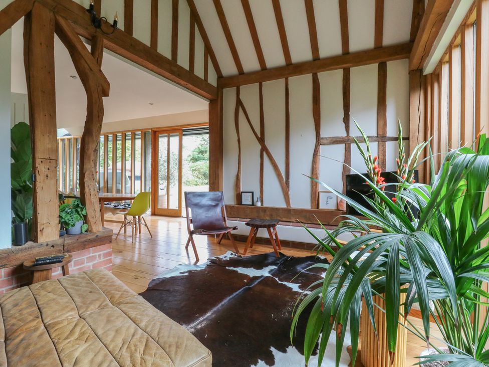 A living room with a sofa and wooden beams at Headland Barn in Maldon