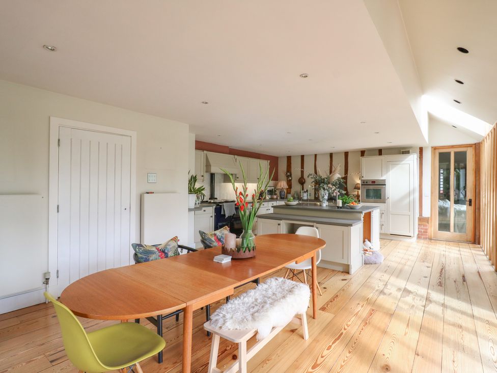 A kitchen with a dining table and chairs at Headland Barn in Maldon
