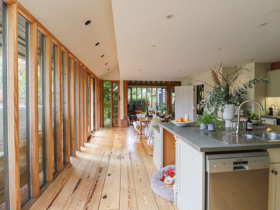 A kitchen with a sink and wooden table at Headland Barn in Maldon