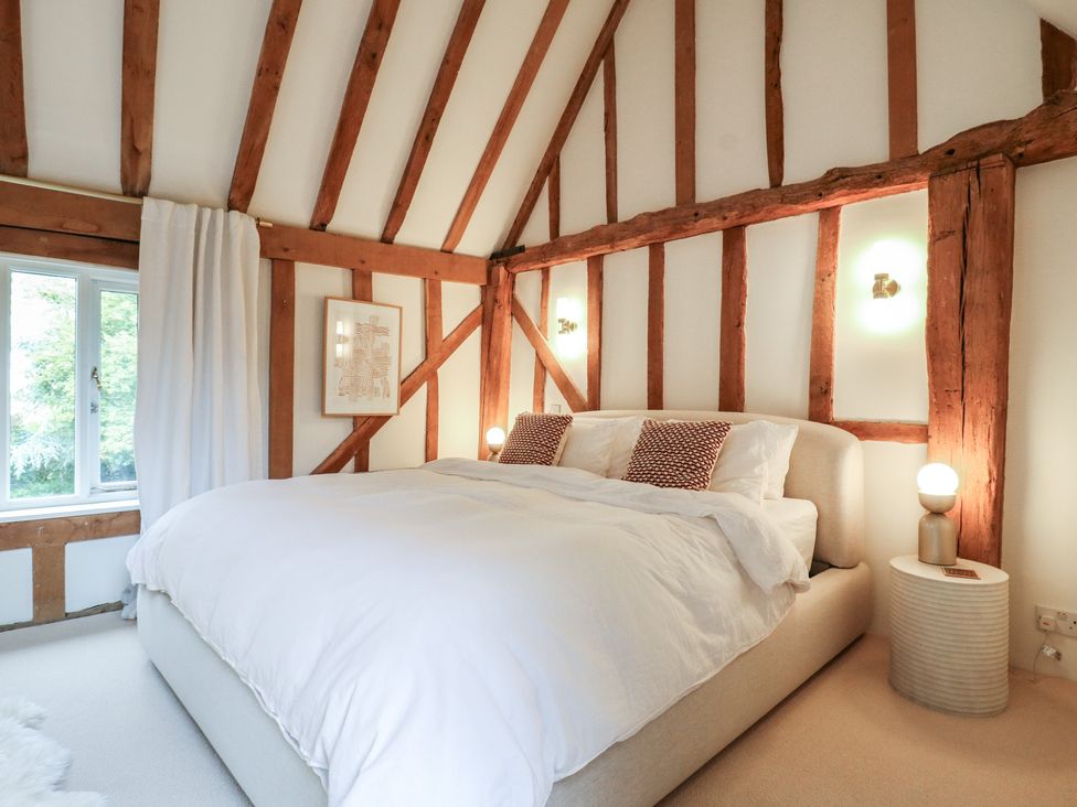 A bedroom with a bed and window at Headland Barn in Maldon