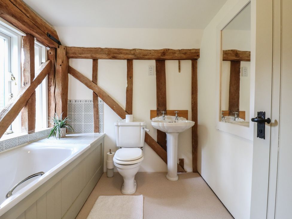 A bathroom featuring a bathtub, toilet, and sink at Headland Barn, Maldon