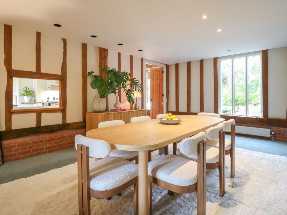 A dining room with a wooden table and chairs at Headland Barn in Maldon