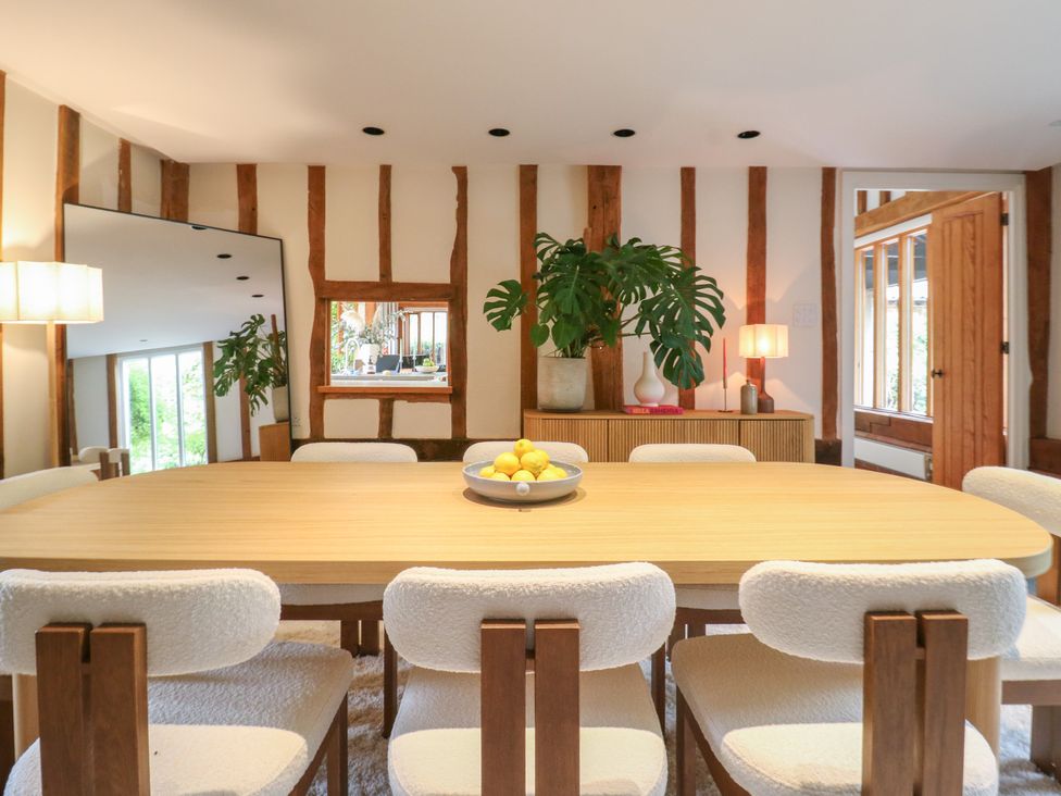 A dining room with a table and chairs at Headland Barn in Maldon