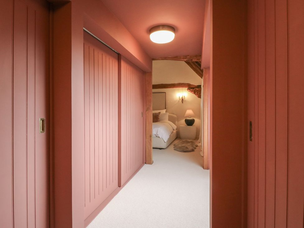 A hallway with doors leading to a bedroom at Headland Barn in Maldon