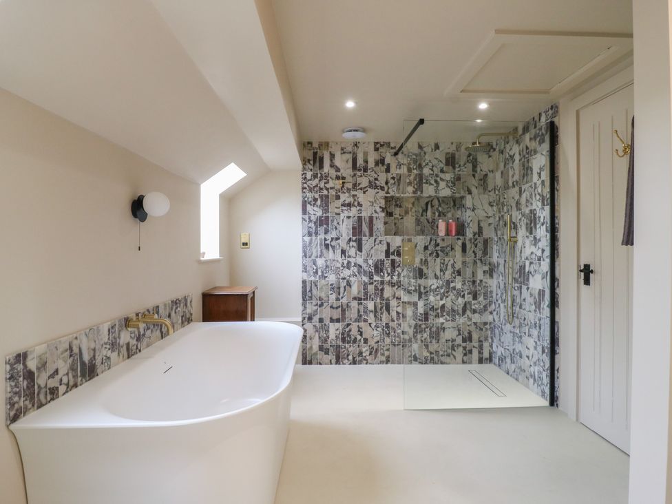 A bathroom with a bath tub and shower at Headland Barn in Maldon
