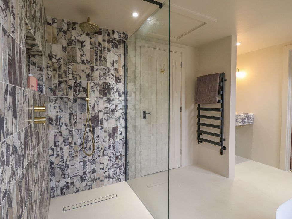 A bathroom with a shower and towel rack at Headland Barn in Maldon