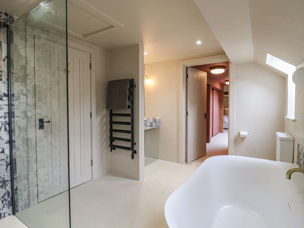 A bathroom with a shower and bathtub at Headland Barn in Maldon