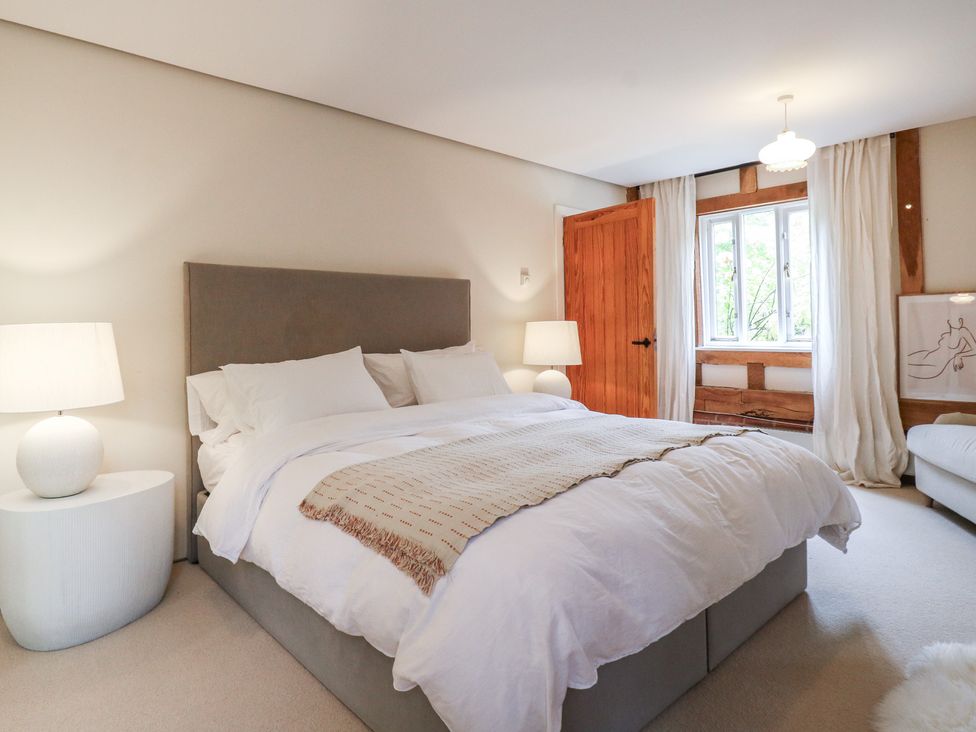 A bedroom with a bed and window at Headland Barn in Maldon