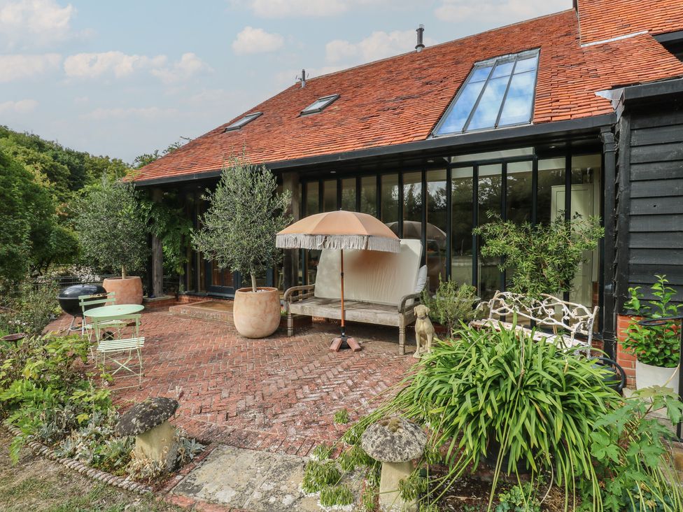An outdoor patio with furniture and plants at Headland Barn in Maldon