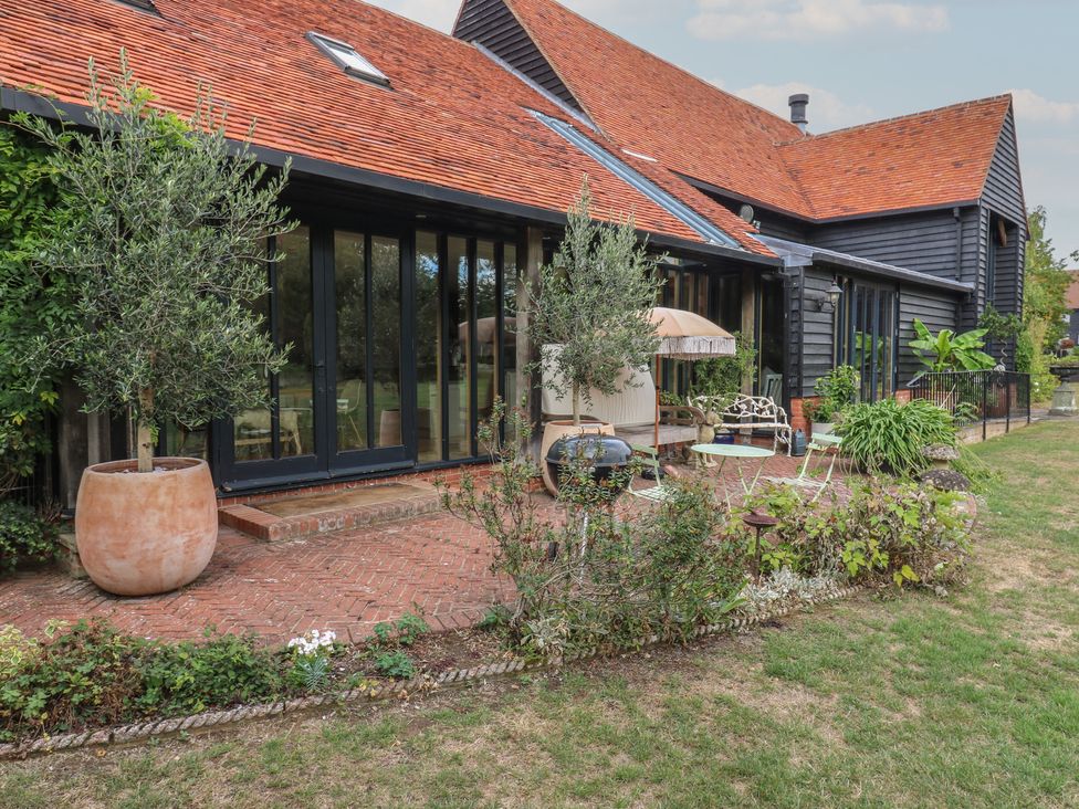 An outdoor patio area with seating and plants at Headland Barn in Maldon