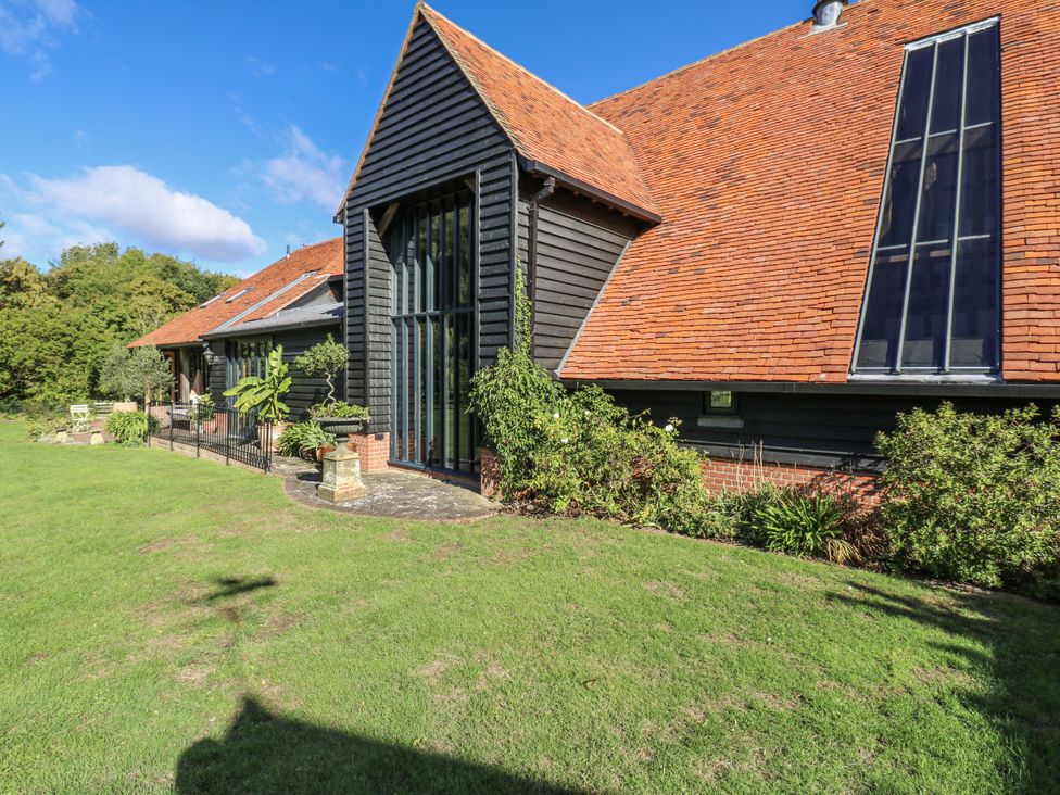 A building with a fence and plants in the garden at Headland Barn Maldon