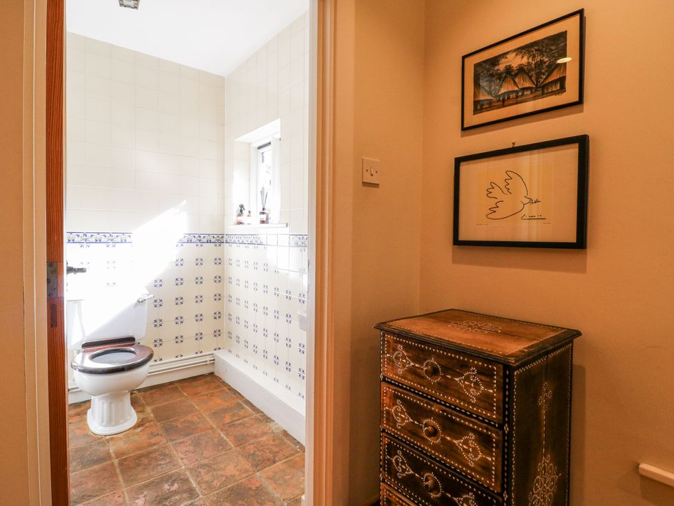A bathroom with a toilet and window at Headland Barn in Maldon