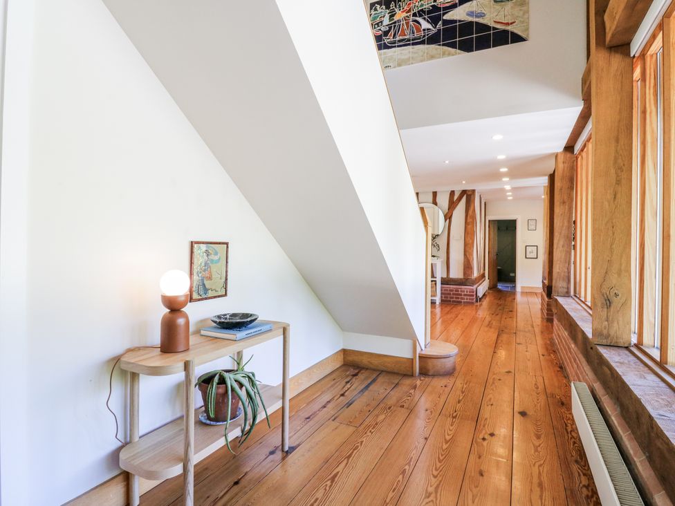 A hallway with a lamp and table at Headland Barn in Maldon