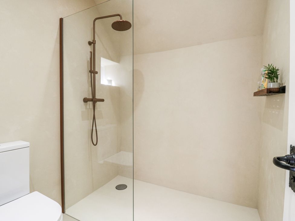 A bathroom with a shower and toilet at Headland Barn in Maldon