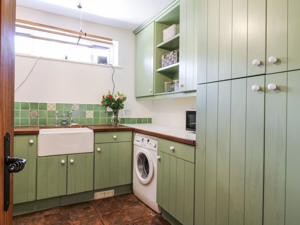 A laundry room with a washing machine and sink at Headland Barn in Maldon