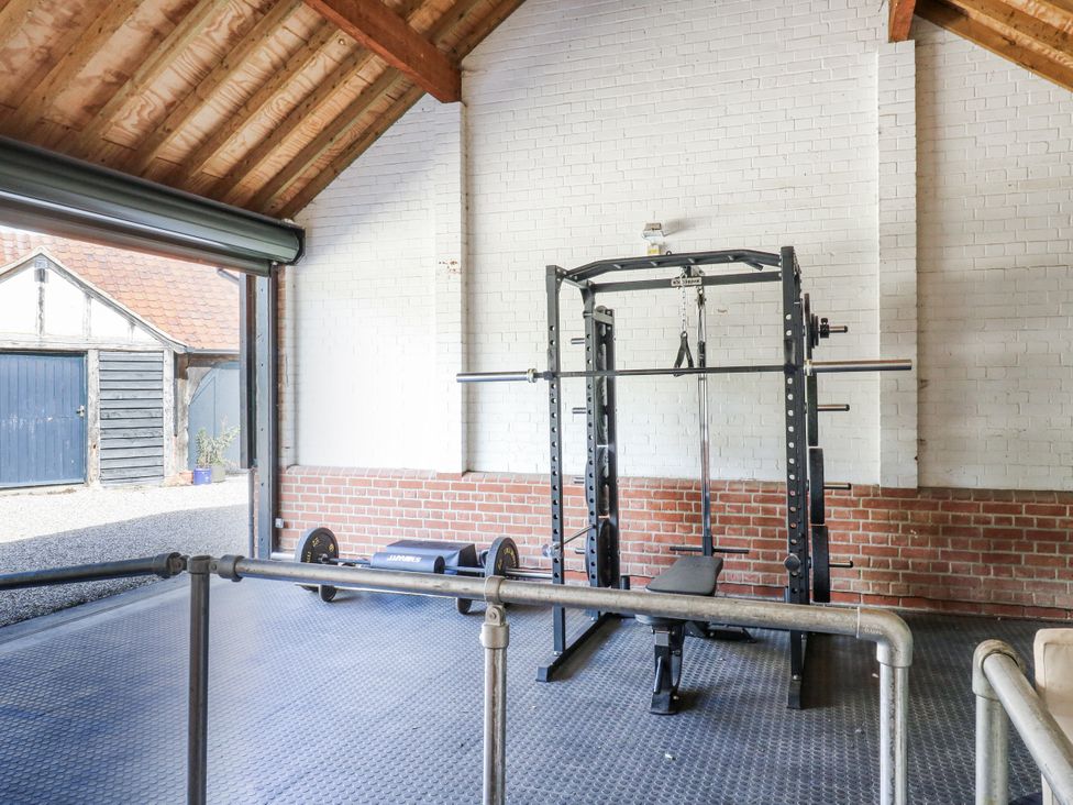 A gym with a power rack and weight bench at Headland Barn in Maldon