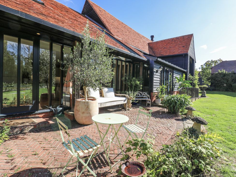 A garden with a table and chairs at Headland Barn Maldon