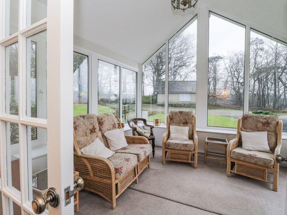 A conservatory with chairs and a table at Carnmhor in Aberdeen