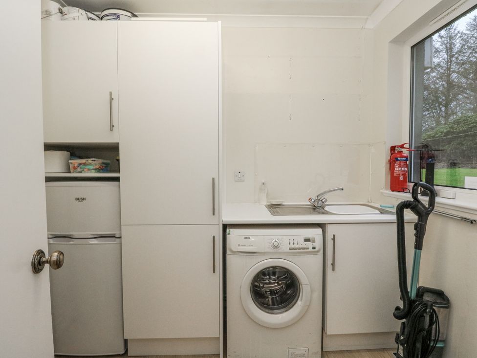 A laundry room with a washing machine and fridge at Carnmhor in Aberdeen