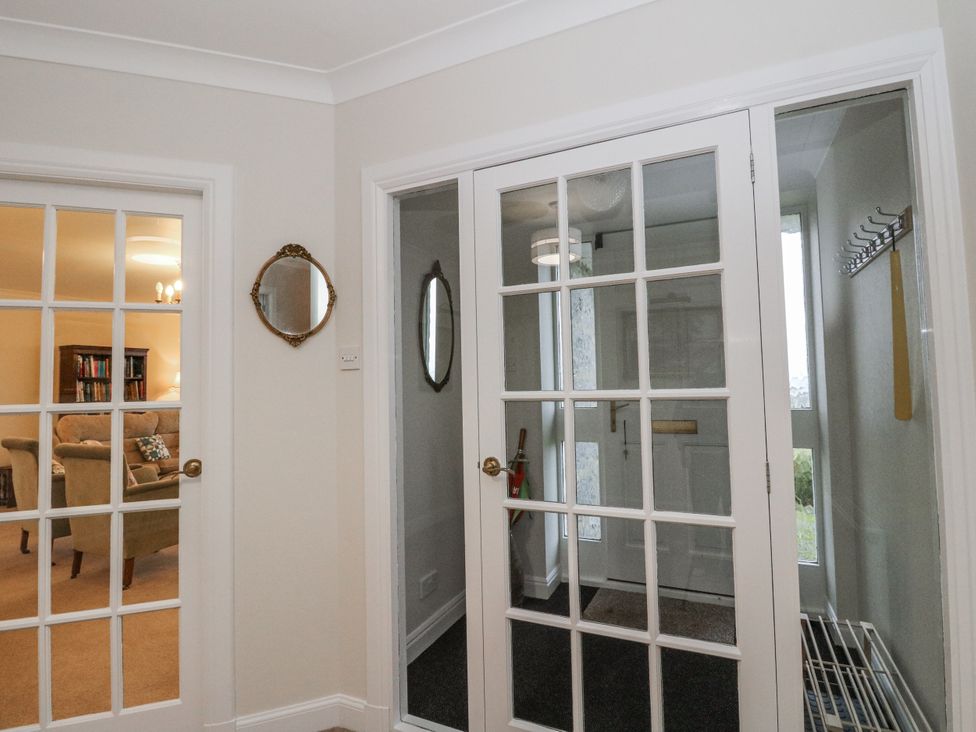 A hallway with a mirror and glass doors at Carnmhor in Aberdeen