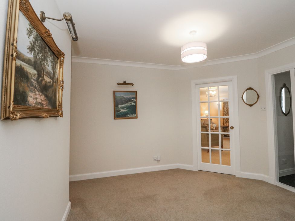 A hallway with paintings and a door at Carnmhor in Aberdeen