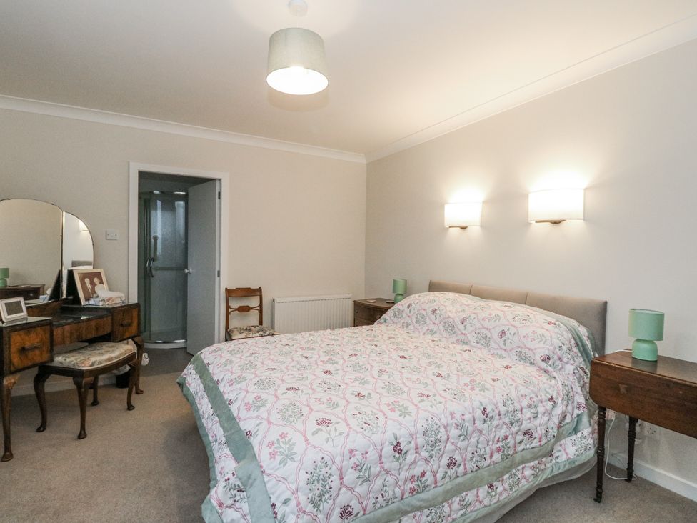 A bedroom with a bed, dresser, and mirror at Carnmhor in Aberdeen